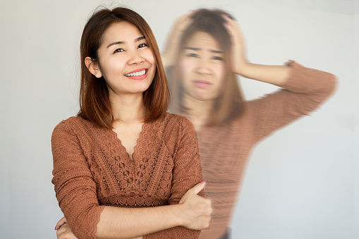 bipolar and smiling depression concept with Asian woman in difference mood , double personality with positive and negative emotional 